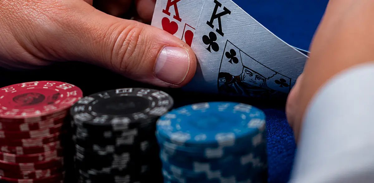 Main de poker tenue au-dessus du tapis